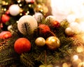 Christmas arrangement with pine twigs, red, white, gold balls, cones on the background of a christmas tree with beautiful bokeh Royalty Free Stock Photo