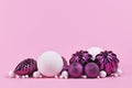 Christmas arrangement with purple and white tree ornament glass baubles on pink background with copy space Royalty Free Stock Photo