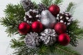 Christmas arrangement with red ornaments, silver and snowy pine Royalty Free Stock Photo