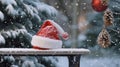 Santa hat on a bench in the snow against the background of the Christmas winter forest Royalty Free Stock Photo