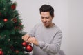 Christmas. Asian man standing new christmas tree at home celebrating New Year.