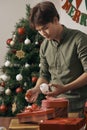 Christmas. Asian man standing new christmas tree at home celebrating New Year.