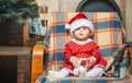 Christmas Babies. Cute little baby child on Christmas tree background. Little baby girl with a Christmas gift on wooden Royalty Free Stock Photo