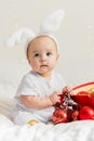 Christmas Baby Child holding christmas bauble near Present Gift Box over Holiday Lights background Royalty Free Stock Photo