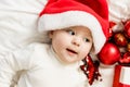 Christmas Baby portrait in Santa Hat, Child holding christmas bauble near Present Gift Box over Holiday Lights Royalty Free Stock Photo