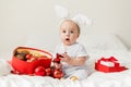 Christmas Baby, Child holding christmas bauble near Present Gift Box over Holiday Lights background Royalty Free Stock Photo