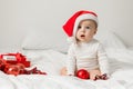 Christmas Baby in Santa Hat, Child holding christmas bauble near Present Gift Box over Holiday Lights background Royalty Free Stock Photo