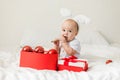 Christmas Baby Child holding christmas bauble near Present Gift Box over Holiday Lights background Royalty Free Stock Photo