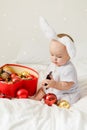 Christmas Baby Child holding christmas bauble near Present Gift Box over Holiday Lights background Royalty Free Stock Photo