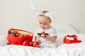 Christmas Baby in Santa Hat Child playing with baubles. Present Gift Box over Holiday Lights background and Merry Royalty Free Stock Photo