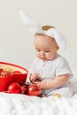 Christmas Baby in Santa Hat Child playing with baubles. Present Gift Box over Holiday Lights background and Merry Royalty Free Stock Photo