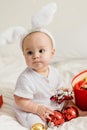 Christmas Baby in Santa Hat Child playing with baubles. Present Gift Box over Holiday Lights background and Merry Royalty Free Stock Photo