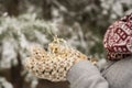 Christmas background with ball of Christmas light in hands clothed with woolen handmade ethnic mittens