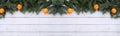 Christmas background. Banner. Spruce branches, tangerine on a white wooden background, flatly laid, top view, copy space