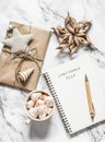 Christmas background - blank notepad with christmas plans, gift box, cup of hot chocolate on a light background, top view Royalty Free Stock Photo