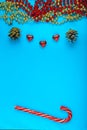 Christmas background blue branch of pine next to cones beads and sweets.