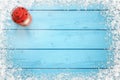 Christmas background. Blue frozen wooden table with snowy snowflakes on edges. Red lantern on left side