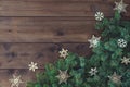 Christmas background with border of fluffy green fir branches on a textured dark brown wood Royalty Free Stock Photo