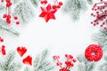 Christmas background border. Red, green and white Xmas composition with fir branch, holly berries and snow. Xmas flat lay top view Royalty Free Stock Photo