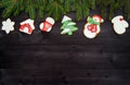 Christmas background border with tasty homemade gingerbread cookies and fir tree branches on wooden table, top view. Royalty Free Stock Photo