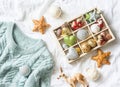 Christmas background. Box of vintage christmas decorations and blue knitted sweater on the bed, view from above. Christmas cozy mo Royalty Free Stock Photo