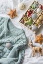 Christmas background. Box of vintage christmas decorations and blue knitted sweater on the bed, view from above. Christmas cozy mo Royalty Free Stock Photo