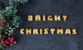 Christmas background with branch of christmas tree and baked gingerbread words bright christmas . creative idea