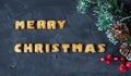 Christmas background with branch of christmas tree with baked gingerbread words merry christmas . creative idea