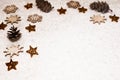 Christmas background, with bronze glitter stars, timber snowflakes, pines cones and snow - sophisticated, luxury - copyspace