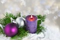 Christmas background with candle and decorations.Purple and silver Christmas balls over fir tree branches in the snow Royalty Free Stock Photo