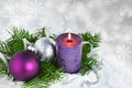 Christmas background with candle and decorations.Purple and silver Christmas balls over fir tree branches in the snow Royalty Free Stock Photo