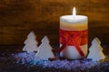 Christmas background with candle light and wooden christmas trees.