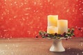 Christmas background with candles decoration over red bokeh