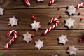 Christmas background. Christmas canes and cookies in the shape of stars on a wooden background.