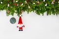 Christmas background. Christmas fir tree branch with Santa and green Christmas ball on white wooden background. Royalty Free Stock Photo