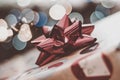 Christmas background of close up of shiny red bow with blurred lights or bokeh in the background Royalty Free Stock Photo