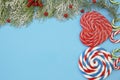 Christmas background or composition with fir branches and candy lollipops shape heart and spiral. Flat lay. Top view. Copy space f