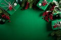 Christmas background concept. Top view of Christmas green gift box with decoration, spruce branches and red berries on green Royalty Free Stock Photo