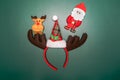 Christmas background concept. Top view of Santa claus and reindeer with head band on green background Royalty Free Stock Photo