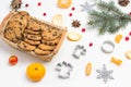 Christmas background with cookies in basket, tangerines, fir branches, cookies molds and cranberries