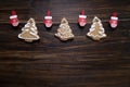 Christmas background with cookies decorated with icing, with clothespins - gloves on a wooden board.