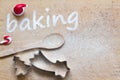 Christmas background with cookies molds, spoon and sweet decoration. Baking text made with flour