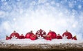 Christmas Background - Decorated Red Balls On Snow with snowflakesand stars on wooden desk Royalty Free Stock Photo