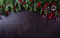 Christmas background decoration concept. Top view of red balls with spruce branches, pine cones, red berries and bell on dark Royalty Free Stock Photo