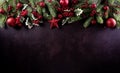 Christmas background decoration concept. Top view of red balls with spruce branches, pine cones, red berries and bell on dark Royalty Free Stock Photo