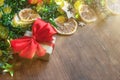 Christmas background with decorative composition of green tinsel, dried oranges, red berres, pine cone, gift with red bow and