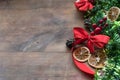 Christmas background with decorative composition of green tinsel, dried oranges, red berres, pine cone, gift with red bow and