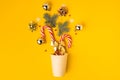 Christmas background with disposable paper cup full of candy canes and decorated with golden Christmas tree toys. Festive feeling Royalty Free Stock Photo