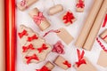 Christmas background - eco handmade gift boxes of kraft paper, tree, labels, roll wrapping paper, red bows and ribbons on white