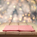 Christmas background with empty wooden table and tablecloth over abstract bokeh lights Royalty Free Stock Photo